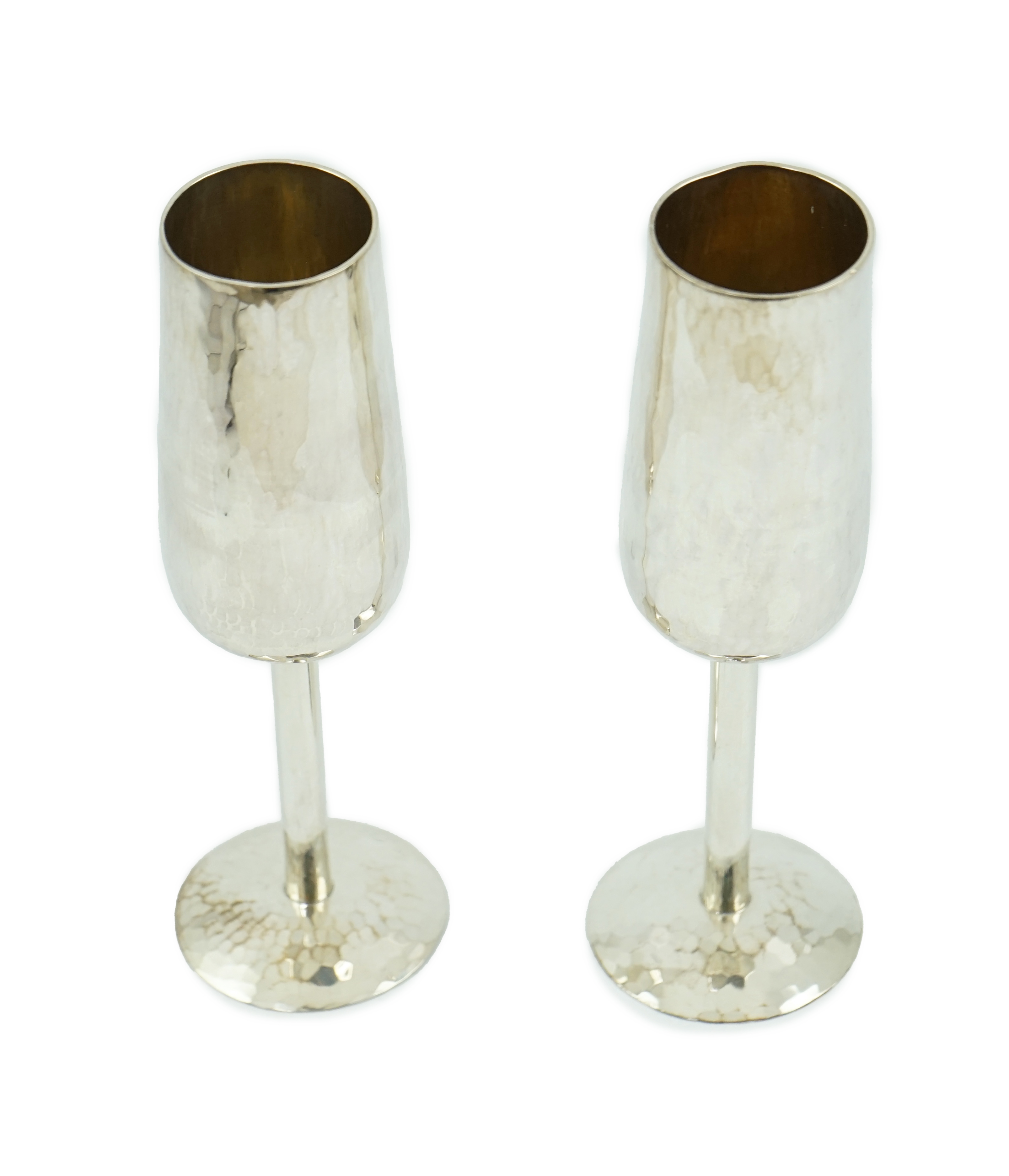 A pair of Elizabeth II planished silver champagne flutes, by Pruden & Smith